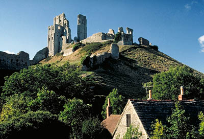 Corfe Castle, viewed over the roofs of cottages in the village center. Location: ENG, Dorset , Dorset AONB, Isle of Purbeck, Corfe. [ref. to #155.064]