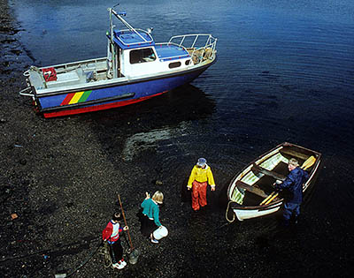 SCO: Highland Region, Skye & Lochalsh District, Isle of Skye, Inner Hebrides, Portree, Harbor. Fishing boat; children wading to rowboat. Ben Chracaig in background. NOT RELEASED. [Ask for #175.054.]