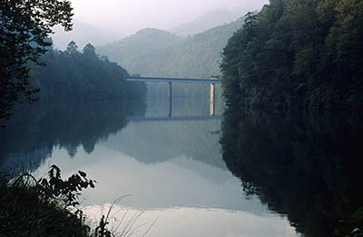 NC 28 bridge over Little Tennessee River, crossing the upper reaches of Lake Cheoah, viewed in morning mist. Location: NC, Swain County, Great Smoky Mountains Nat. Park, Fontana Dam Area. [ref. to #180.026]