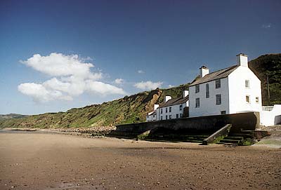 Cottages on beach, underneath sea cliffs. Location: WAL, Gwynedd County, Lleyn Peninsula, Porth Dinllaen (bay), Morfa Nefyn (village). [ref. to #184.073]