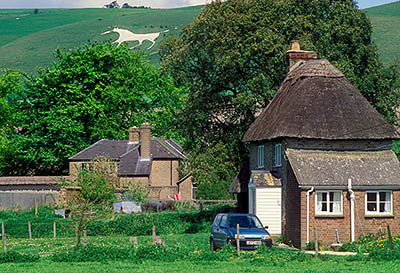 Alton Priors. Thatched self-catering cottage beneath downs; Walker Hill White Horse in bkgd. Near the southern end of the Ridgeway. Location: ENG, Wiltshire , The Vale of Pewsey, Pewsey Area, The Altons. [ref. to #197.009]