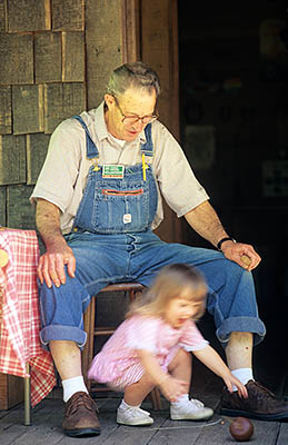 Local toymaker & NFS volunteer, Bob Miller, demos hand-made top to small girl, Lea Kilpatrick. Motion blurred. REL. Location: NC, Transylvania County, Pisgah National Forest, Davidson River Area, The Cradle of Forestry In America. [ref. to #212.204]