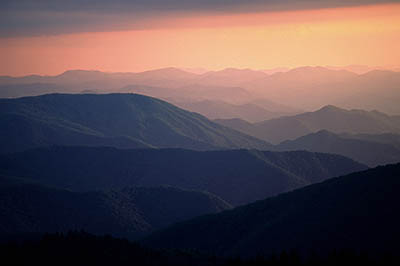 View west from the crest of the Great Balsam Mountains, over the Nantahala National Forest, at sunset. Location: NC, Jackson County, The Blue Ridge Parkway, Cowee Mountain Overlook, MP 431. [ref. to #212.236]