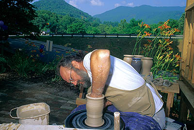 Craft artist Brant Barnes of Dillsboro throwing pottery; mt.s in bkgd; RELEASED. Location: NC, Jackson County, Sylva Area, Dillsboro. [ref. to #216.032]