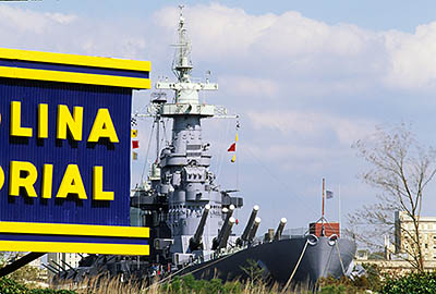 NC: New Hanover County, Cape Fear River Area, Wilmington,  U.S.S. North Carolina Battleship, View of battleship behind entrance sign [Ask for #224.131.]