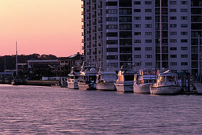 Yachts moored by condominium tower at dusk. Location: NC, New Hanover County, Wilimington Area, Wrightsville Beach. [ref. to #224.209]