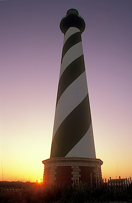 Sun setting behind lighthouse. Location: NC, Dare County, The Outer Banks, Hatteras National Seashore, Cape Hatteras Lighthouse. [ref. to #224.397]