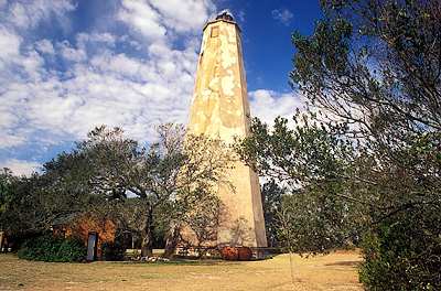 Viewed from the east, showing brick outbuilding (ctr) under oaks. Location: NC, Brunswick County, Cape Fear Area, Bald Head Island, Bald Head I. Lighthouse (Old Baldy). [ref. to #233.026]