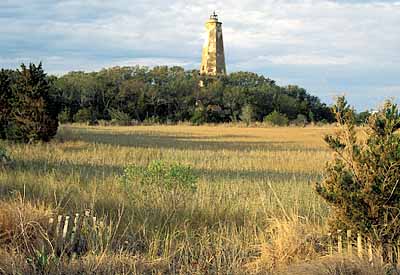 Viewed from the west, over salt marshes; dune stabilization fencing, btm. Location: NC, Brunswick County, Cape Fear Area, Bald Head Island, Bald Head I. Lighthouse (Old Baldy). [ref. to #233.045]