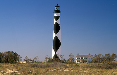 Lighthouse, with lightkeeper's cottage. Viewed over ocean-side dunes. Location: NC, Carteret County, Cape Lookout Nat. Seashore, Cape Lookout, Cape Lookout Lighthouse. [ref. to #233.490]