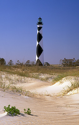 The lighthouse, with lightkeeper's cottage. Viewed over ocean-side dunes. Location: NC, Carteret County, Cape Lookout Nat. Seashore, Cape Lookout, Cape Lookout Lighthouse. [ref. to #233.492]