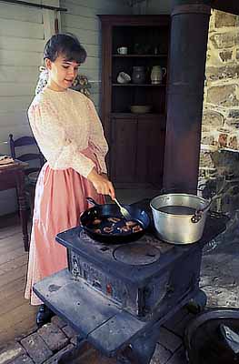 Market Day Festival; Sarah Bahnson cooking fatback on a wood stove in the Duke Farmstead kitchen. RELEASED. Location: NC, Durham County, Tri-Cities Area, Durham, Duke Homestead & Tobacco Museum. [ref. to #233.712]