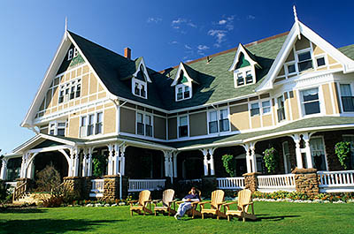 PE: Queens County, Anne's Land Area, Prince Edward Island National Park, The Delvay-by-the-Sea Hotel. Front view; woman relaxing on a lawn chair. MR. [Ask for #240.049.]