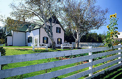 PE: Queens County, Anne's Land Area, House of Green Gables, PEI Nat. Park, Side view of the house, over a white fence, with autumn flowers. [Ask for #240.076.]