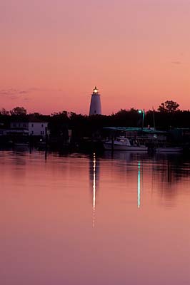 NC: Hyde County, Hatteras National Seashore, Ocracoke Island, Ocracoke Island Docks, on Pamlico Sound, Sunset view from national park service docks, over the village harbor (known as Silver Lake), towards lighthouse [Ask for #241.338.]