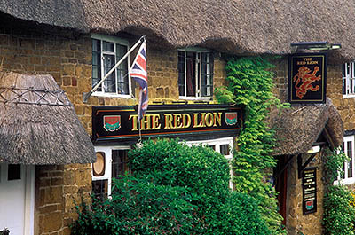 ENG: Thames & Chilterns Region, Oxfordshire, Upper Cherwell Valley, Banbury, Cropredy, The Red Lion Inn, c 15th C.; view of front entrance, showing gold limestone walls and thatched roof [Ask for #243.010.]