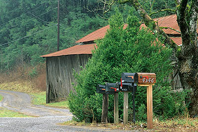 Mailboxes and a red-roofed barn by a country lane. Location: TN, Sevier County, Smoky Mountains, Gatlinburg, Boogertown. [ref. to #245.226]