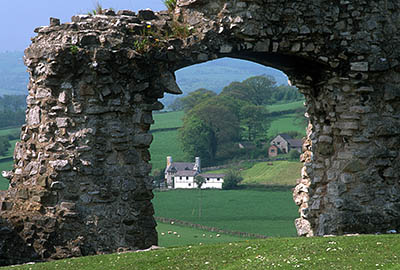 View through a ruined arch towards a Welsh farmhouse. Location: WAL, Denbighshire County, Vale of Clwyd, Denbigh, Denbigh Castle. [ref. to #246.008]