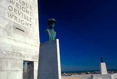 Front of monument to the Wright Brothers, with busts of Orville and Wilbur Wright; beach and town visible in far background. Location: NC, Dare County, The Outer Banks, Kitty Hawk Area on Bodie Island, Wright Brothers Nat. Memorial. [ref. to #249.087]