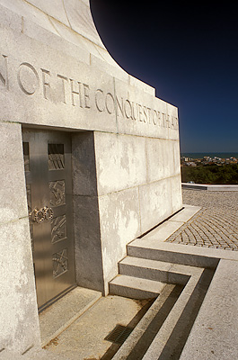 Front of monument, showing door; beach and town visible in far bkgd. Location: NC, Dare County, The Outer Banks, Nags Head & Kitty Hawk, on Bodie Island, Wright Brothers Nat. Memorial. [ref. to #249.089]