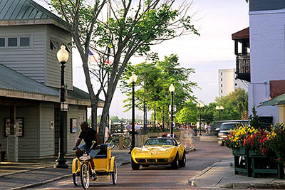 NC: New Hanover County, Cape Fear River Area, Wilmington, Riverfront, Water Street, by the River Walk; a yellow Corvette follows a yellow pedal-cart [Ask for #249.344.]