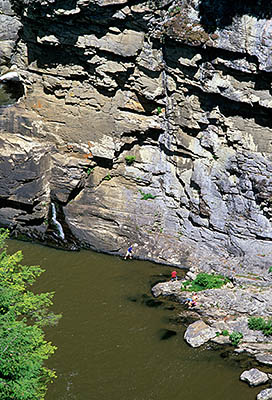 NC: Burke County, The Blue Ridge Parkway, Linville Falls, Linville Falls, View across Linville Gorge towards cliffs by the Lower Falls, with a family playing in the water at the foot of the cliffs [Ask for #252.424.]