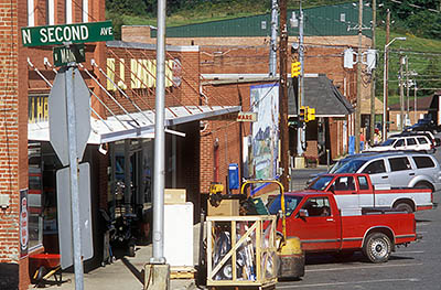 NC: Ashe County, New River Valley, Jefferson Area, West Jefferson, A hardware store anchors the busy red brick stores, the street lined with pickup trucks; street sign reads "N Second Ave" [Ask for #260.299.]