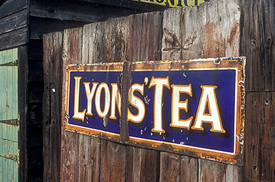 ENG: Northumbria Region, Durham, Beamish, The North of England Open Air Museum, The Colliery, "Lyons' Tea" sign on a rough wood fence [Ask for #262.337.]