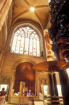 ENG: Northumbria Region, Durham, Durham Borough, Medieval Durham, Durham Cathedral. Interior; Pascal Candle at the west end of the Nave, with baptismal font rt. and visitor information desk bkgd [Ask for #262.369.]