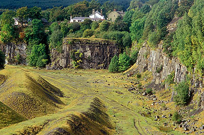 ENG: Northumbria Region, Durham, Stanhope, Houses crowd against the high wall of an abandoned quarry, with views over the Pennines [Ask for #262.395.]