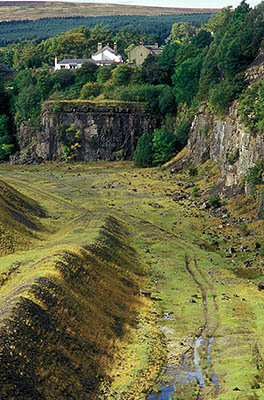 ENG: Northumbria Region, Durham, Stanhope, Houses crowd against the high wall of an abandoned quarry, with views over the Pennines [Ask for #262.396.]