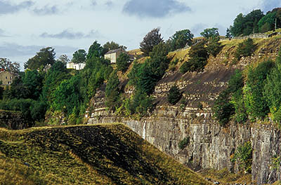 ENG: Northumbria Region, Durham, Stanhope, Houses crowd against the high wall of an abandoned quarry, with views over the Pennines [Ask for #262.397.]