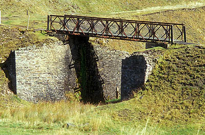 ENG: Northumbria Region, Durham, Stanhope, A public footpath crosses an abandoned strip mine, crossing a stone built feature on a modern steel foot bridge [Ask for #262.400.]