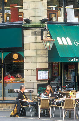 ENG: The Northwest Region, Cumbria, Lake District National Park, Windermere Area, Windermere Town, Motion blurred eople eat at sidewalk cafe in the center of town. [Ask for #262.416.]