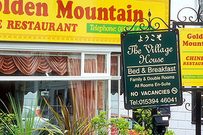 ENG: The Northwest Region, Cumbria, Lake District National Park, Windermere Area, Windermere Town, A bed and breakfast sign competes with a Chinese restaurant sign at the center of town [Ask for #262.417.]