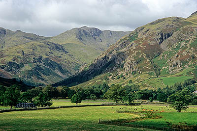 ENG: The Northwest Region, Cumbria, Lake District National Park, Central Lakes Area, Great Langdale, View over valley meadows towards the high, cliff-sided mountain peaks of Crinkle Crags [Ask for #262.431.]