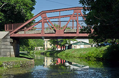 MD: Washington County, Potomac River Gorge, Hancock, Chesapeake and Ohio Canal National Historic Park, Steel truss bridge, painted red, crosses the canal in the center of town. [Ask for #269.052.]