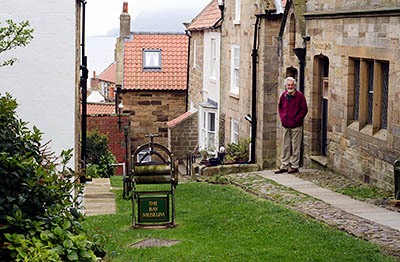 ENG: Yorkshire & Humberside Region, North Yorkshire, North Yorkshire Coast, Sea Cliffs, Robin Hood's Bay, Alan Staniforth, Honorary Curator of Robin Hood's Bay Museum, in front of the museum [Ask for #270.068.]