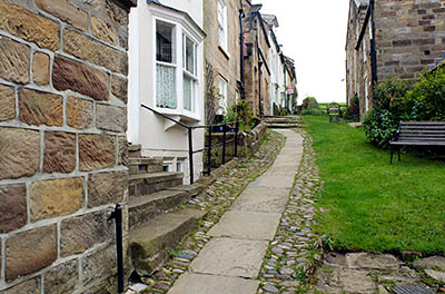 ENG: Yorkshire & Humberside Region, North Yorkshire, North Yorkshire Coast, Sea Cliffs, Robin Hood's Bay, Robin Hood's Bay Museum fronts on a grassy path with stone steps [Ask for #270.075.]