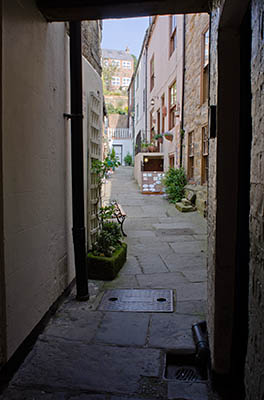 ENG: Yorkshire & Humberside Region, North Yorkshire, North Yorkshire Coast, Whitby, Town Center, View down Blackburns Yard, one of many tiny passageways leading off Church Street, a pedestrianized shopping district carrying the Cleveland Way [Ask for #270.201.]