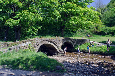 ENG: The Northwest Region, Lancashire, The Pennines, Pendle, Wycoller Country Park, Families play by pack horse bridge near ruinous18th c. Wycoller Hall, the model for Ferndean Manor in "Jane Eyre". The Bronte Way and Pennine Bridleway pass. [Ask for #270.306.]