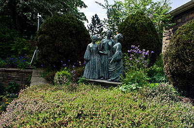 ENG: Yorkshire & Humberside Region, West Yorkshire, Bradford Borough, Haworth, Bronte Parsonage Museum, Statue of the Bronte sisters in the museum garden [Ask for #270.407.]