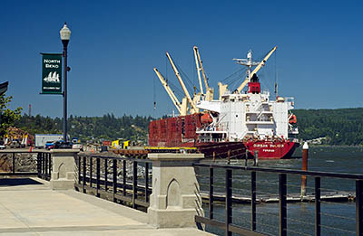 OR: South Coast Region, Coos County, Coos Bay Area, City of North Bend, Waterfront, A ship loads logs by the boardwalk [Ask for #271.114.]